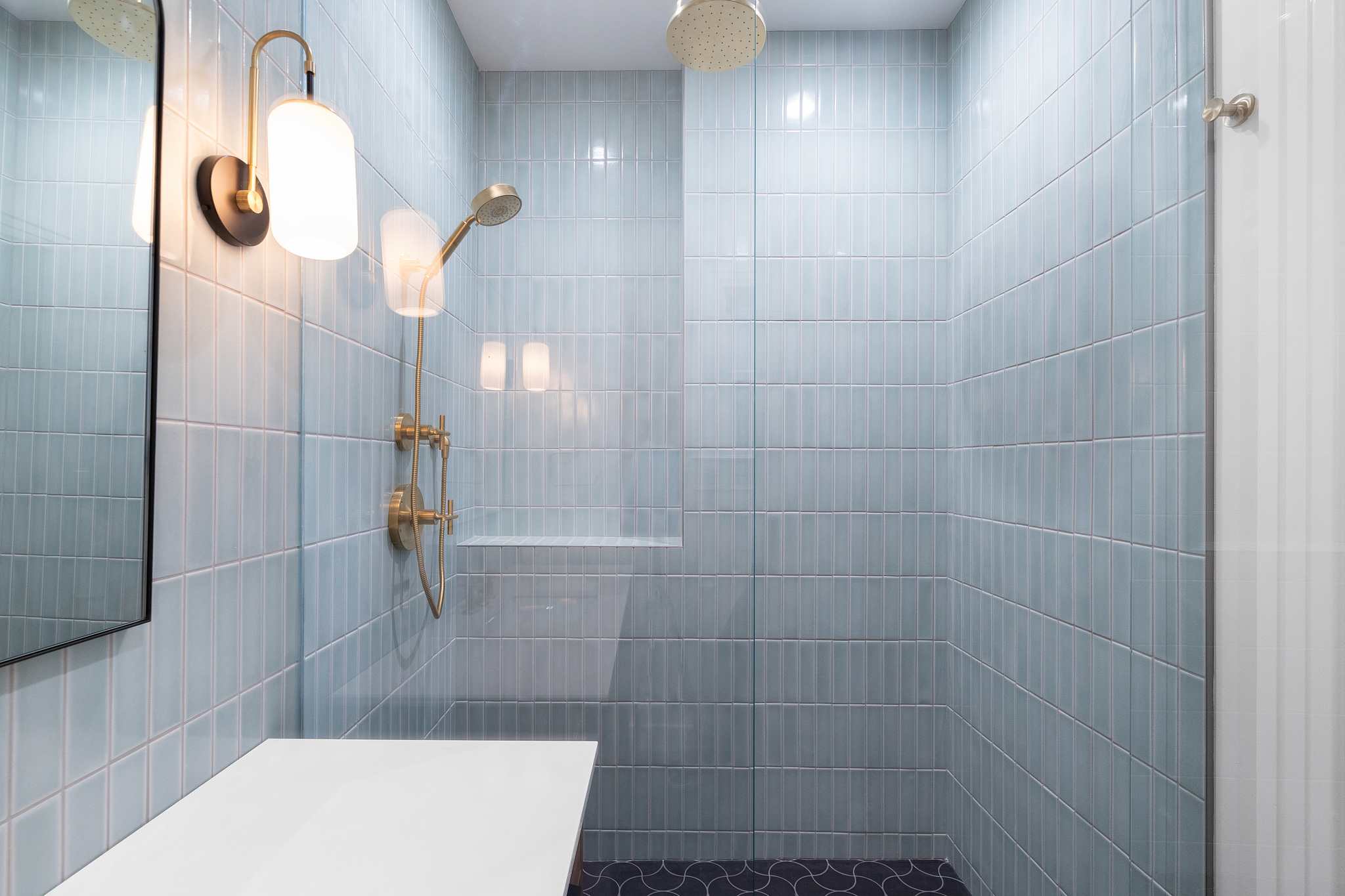 View of the walk-in glass shower with blue tile